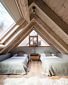Twin beds in bedroom with wood panelling and large skylight