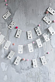 DIY garlands made from book pages with punched heart motifs and pompoms