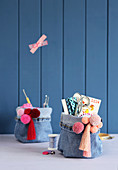 Handmade denim organisers decorated with pompoms and fringes
