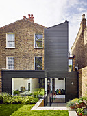 Brick house with modern wood-clad extension and swivelling terrace doors