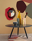 Structured vases on round coffee table in front of painted wall