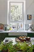 Cake on counter and sink below window with bars