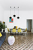 Gelbe Stühle am Esstisch im Wohnzimmer mit Fliesenboden