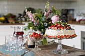 Strawberry cake and crystal glasses on rustic wooden table