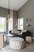 Pouffe and sofa in living room with grey walls