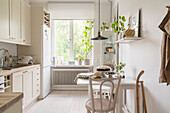 Table with two chairs in light kitchen with white oiled wooden floor