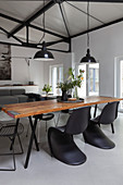Rustic dining table and classic chairs in open-plan interior