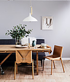 Leather chairs and upholstered bench at wooden table in dining room