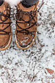 Feet wearing winter shoes in snow