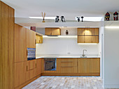 Kitchen with wooden cabinet, stone tiles and skylights