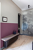 Delicate bench against wall painted in shades of grey and berry in hall