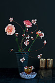 Modern arrangement of carnations and branches of laurustinus flowers with leaves removed