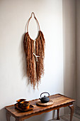 Ethnic-style wall hanging made from raffia threads and ring