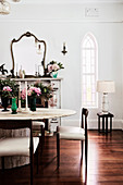 Ovaler Travertin-Tisch mit Stühlen vor Kamin mit Spiegel im Esszimmer