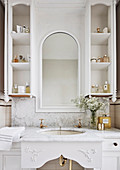 Washstand with marble top, above it round-arched mirror flanked by shelves