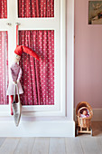 Rag doll hanging from wardrobe door in girl's bedroom