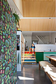 Moderne Küche mit gemusterter Tapete, grünen Unterschränken und Treppe