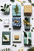 Gifts festively wrapped in shades of green and decorated with twigs