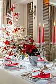 Festlich gedeckter Tisch und Weihnachtsbaum in Rot und Weiß