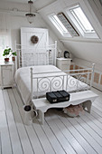 A white bed in an attic bedroom
