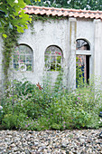 An old wall with arched windows in a garden