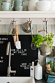 An open shelf with hooks in a kitchen