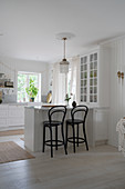 Breakfast counter with bar stools in white kitchen