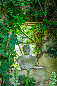 Overgrown stone wall with antique bust