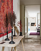 Artwork displayed with red wall covering in atelier hallway