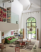 Triple-height living space with mezzanine and old textiles adding colour
