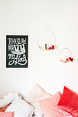 Two golden metal rings with decorations and candles next to motto poster