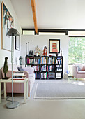 Pink sofa and modular shelving in living room with glass wall
