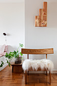 Holzstuhl mit Tierfell vor der Wand im Schlafzimmer