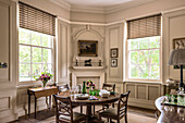 Wooden dining table and chairs in cream panelled room