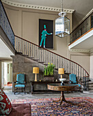 Classic entrance hall with winding staircase and a painting of a jester