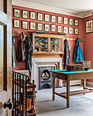 Picture gallery above a wall mounted cabinet and English style stove in the hallway
