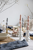 Arrangement of artistically twisted, pastel-coloured candles on table