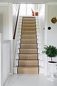 White wooden staircase with stair runner