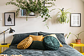 Houseplants and double bed in the bedroom in shades of yellow and green