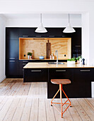 Contemporary kitchen with black cupboard fronts and counter