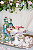 Cake with sugar flowers on a cake stand under a flower wreath