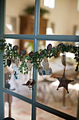 Garland of box branches with nostalgic ornaments hung on a window