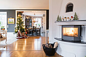 Fire in fireplace, Christmas tree with lights and kitchen-dining room in background