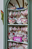 Vintage-style pink service on shelves in arched niche