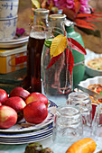 Set table in an autumn garden with apples and autumn leaves