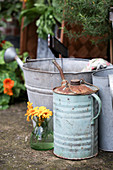 Bouquet of marigolds next to old oil can and zinc bucket