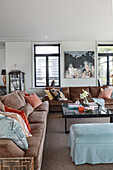 Sofas in shades of brown with scatter cushions and coffee table in lounge