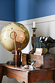 Globus, Holzkiste und nostalgischer Trödel auf altem Holztischchen