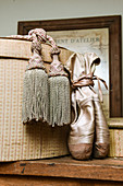 Tassels and ballet shoes arranged next to old hat box