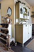 Bin shelves around the corner from old dresser in open-plan, shabby-chic kitchen